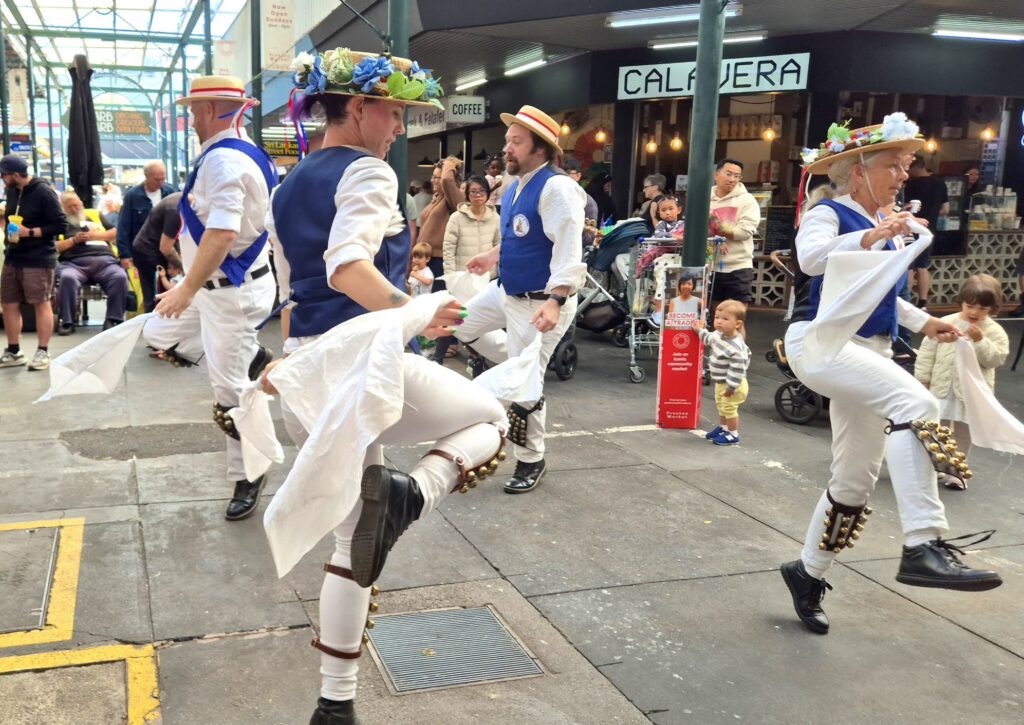 Dancing at Preston Market. The dancers all have one leg bent, in the air.